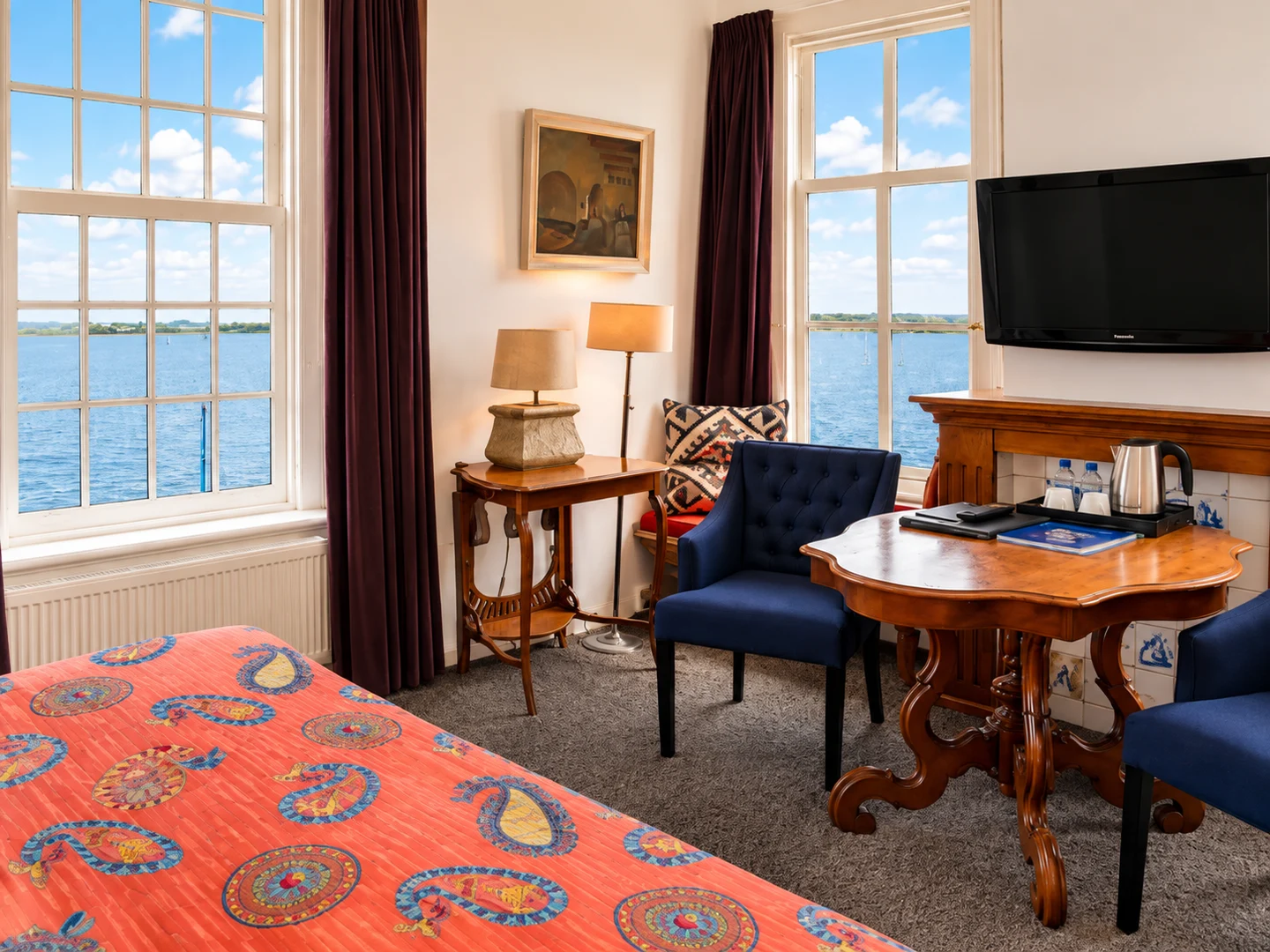 De zithoek van de Schotse Kamer met blauwe fauteuils en uitzicht over het Veerse Meer