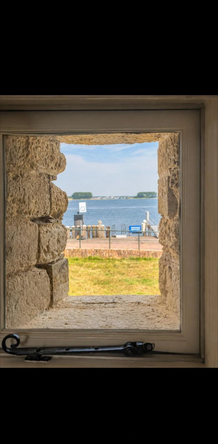 Uitzicht op het Veerse Meer door het kleine raam in de dikke stenen muur van de Vestigingskamer